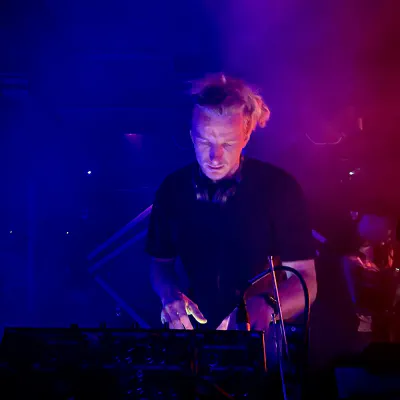 DJ an den Decks unter blauem und violettem Bühnenlicht